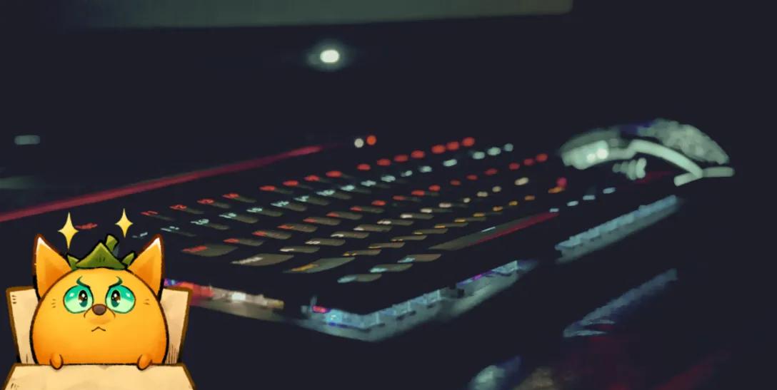 A keyboard from a gaming setup alongside an Axie Infinity cartoon creature logo