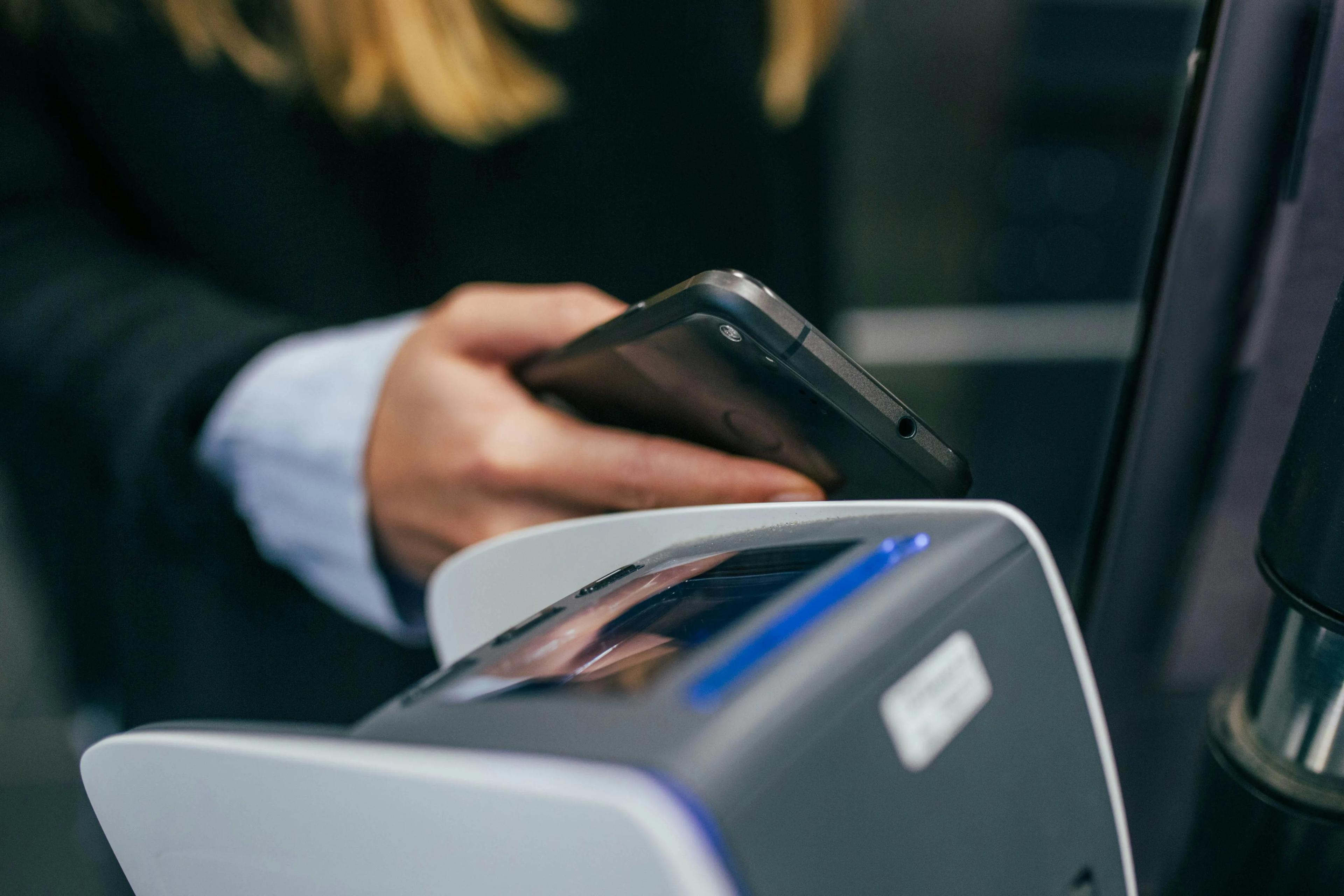 Someone tapping their payment card against a machine