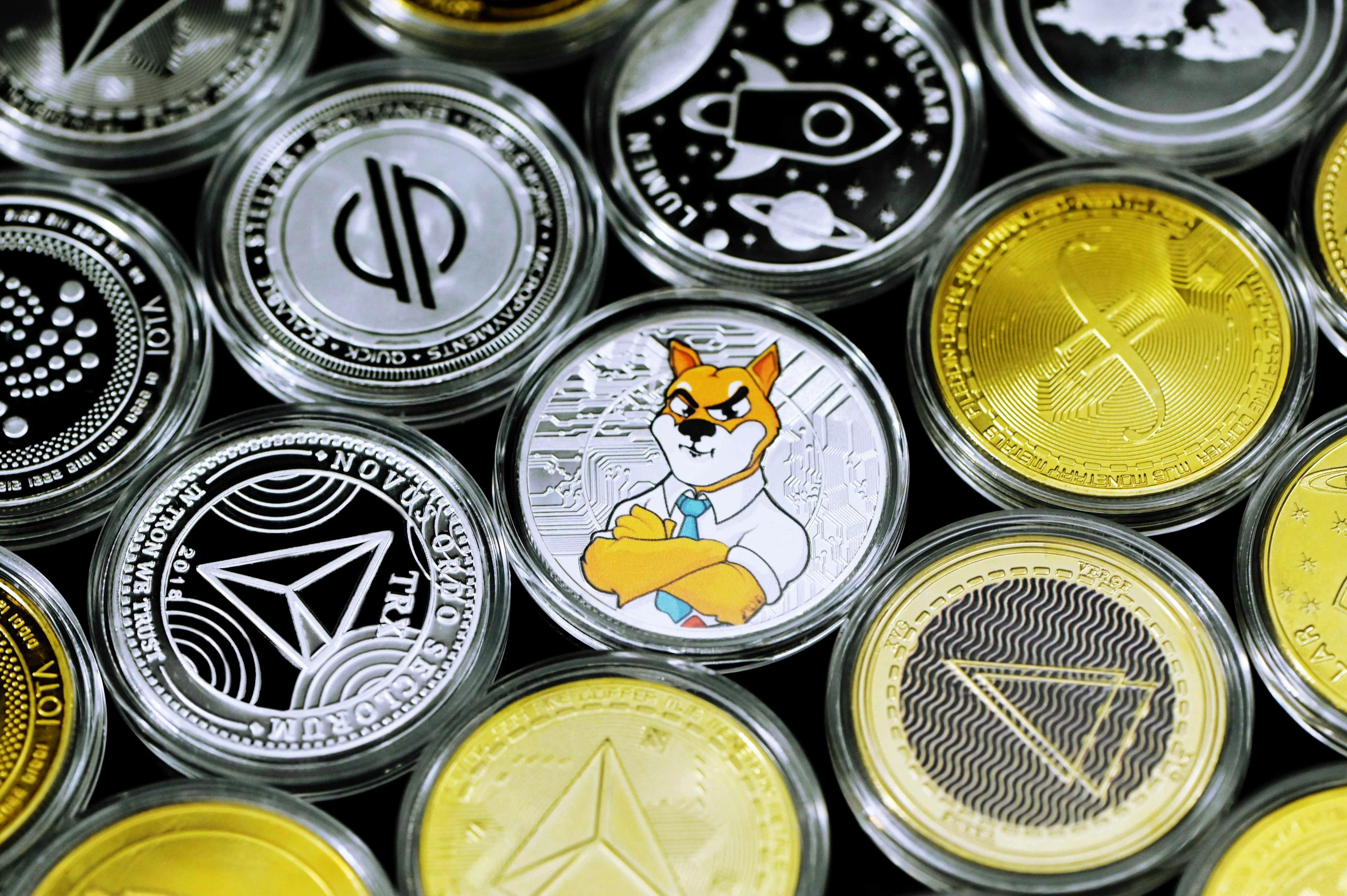A pile of cryptocurrency coins, including one with the Shiba Inu logo