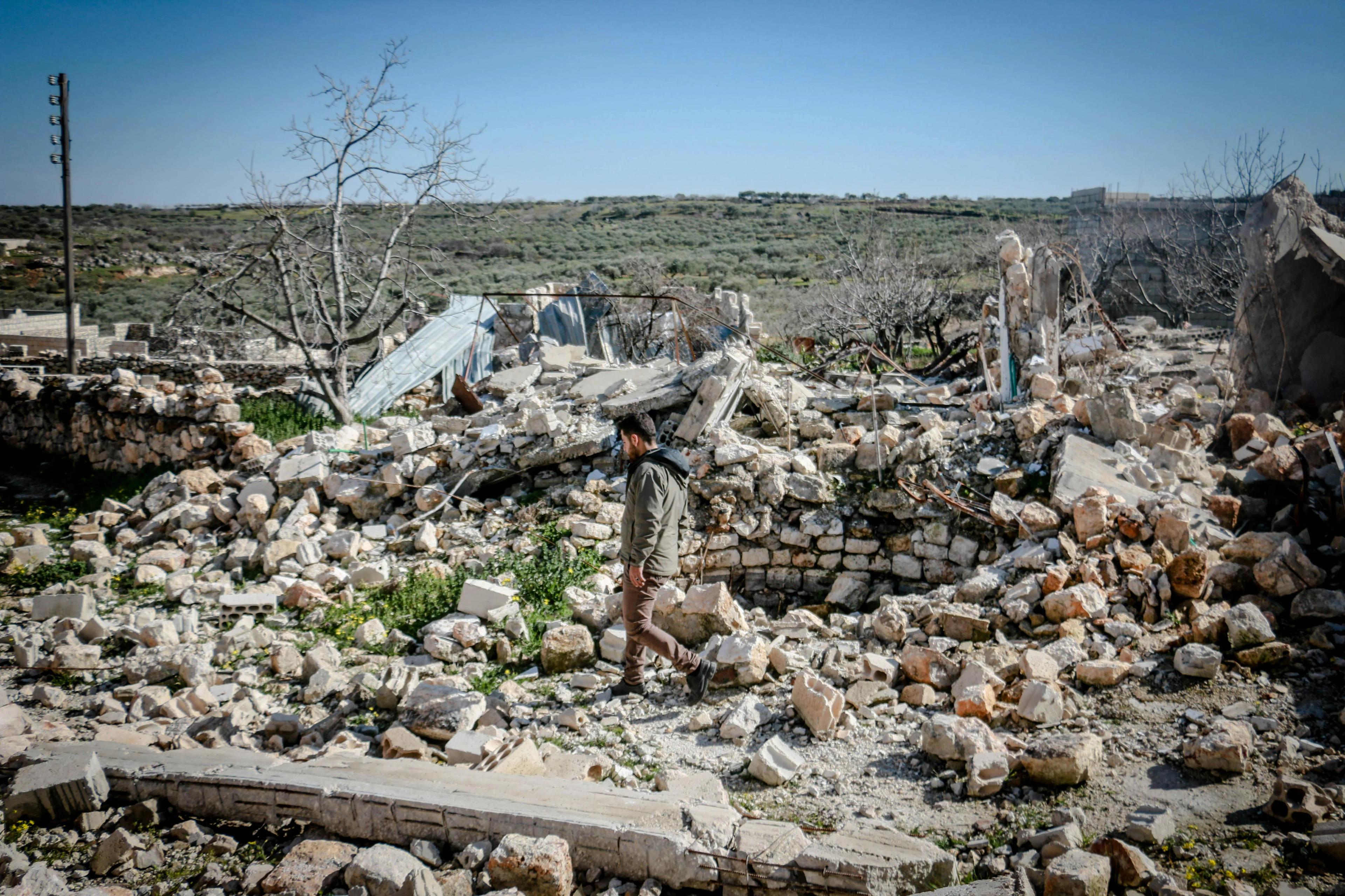 Man walks through rubble in war-torn Syria