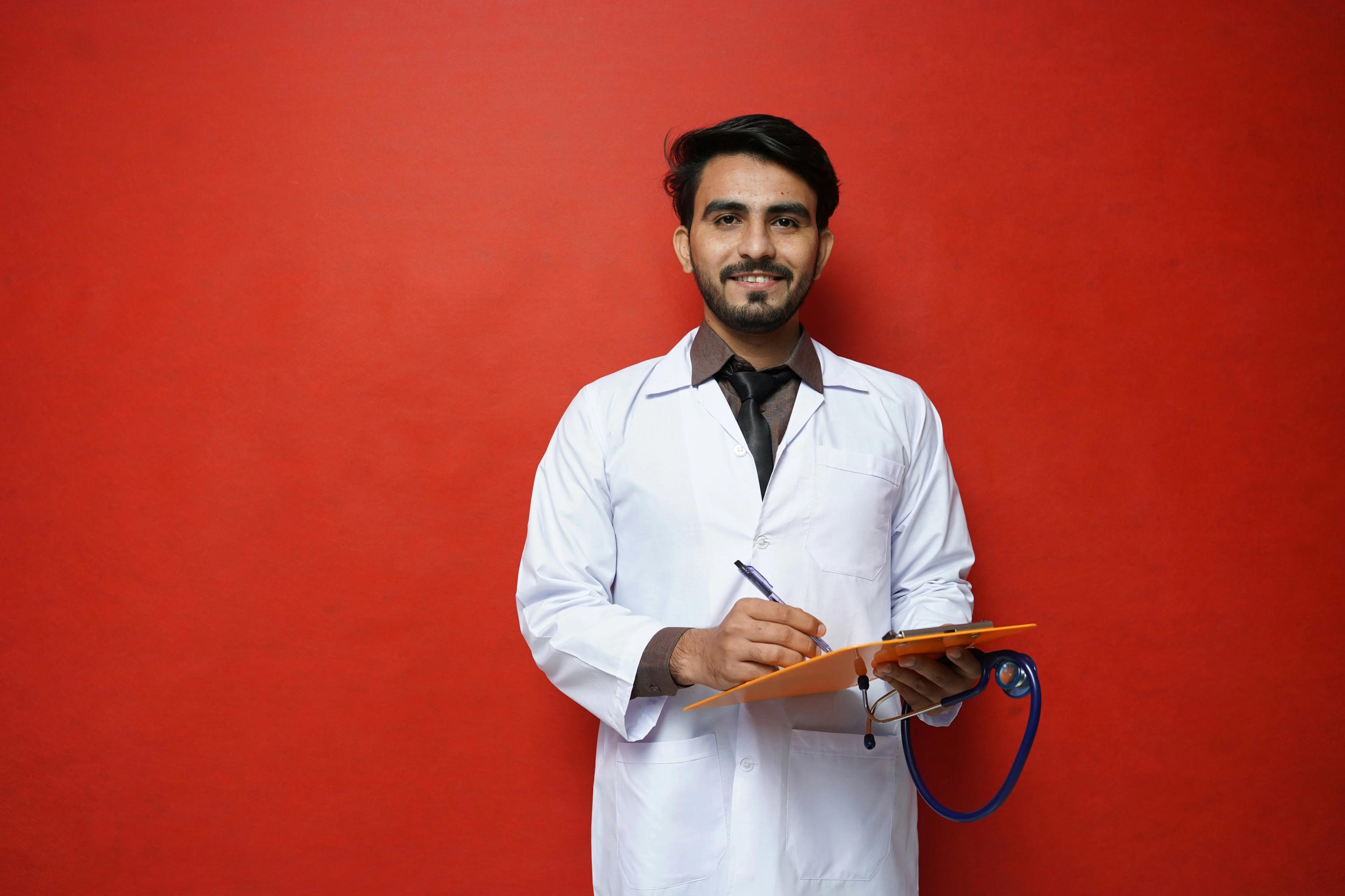 Researcher in lab coat and with clipboard standing in front of a red background