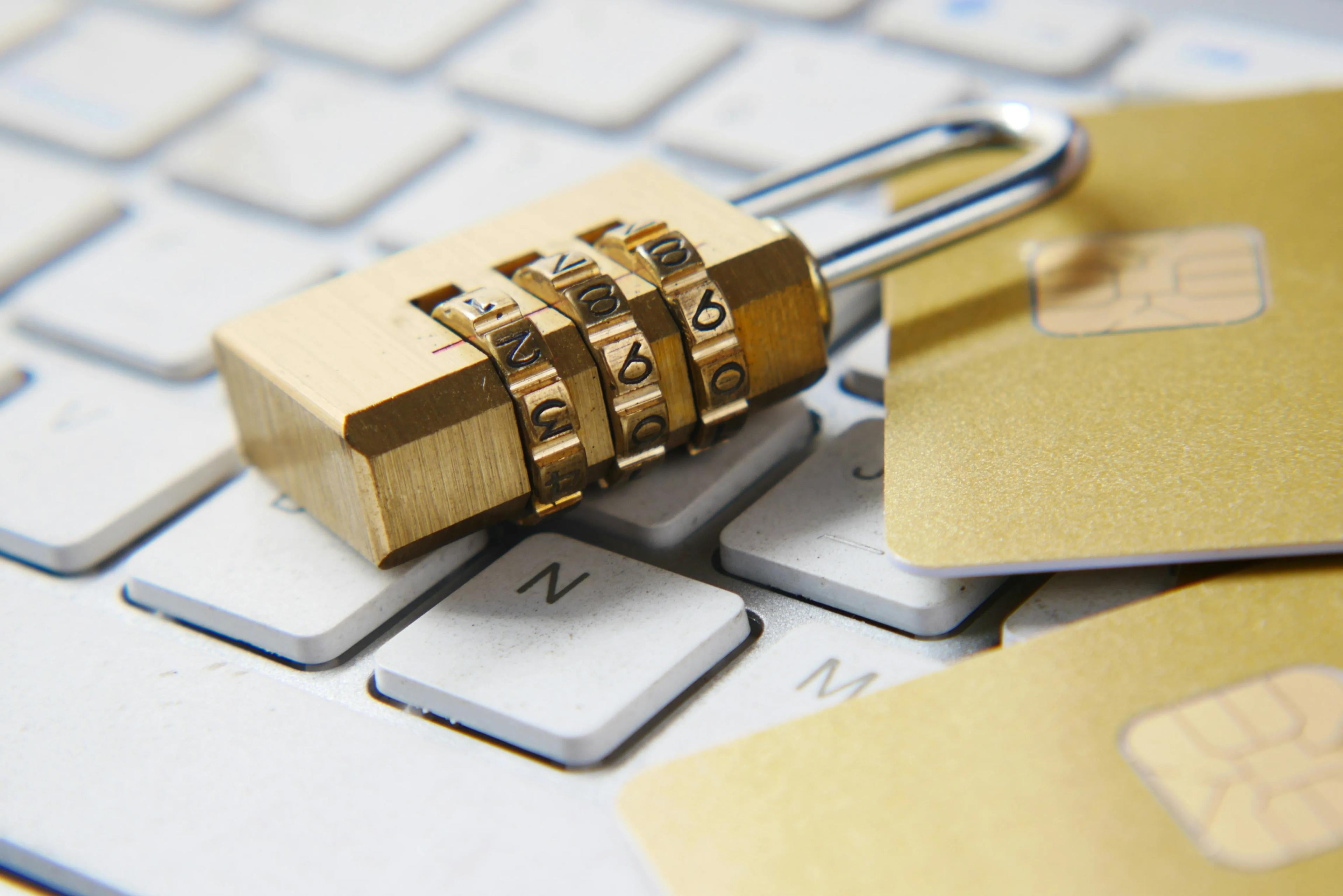 Padlock and credit cards laying on a computer keyboard